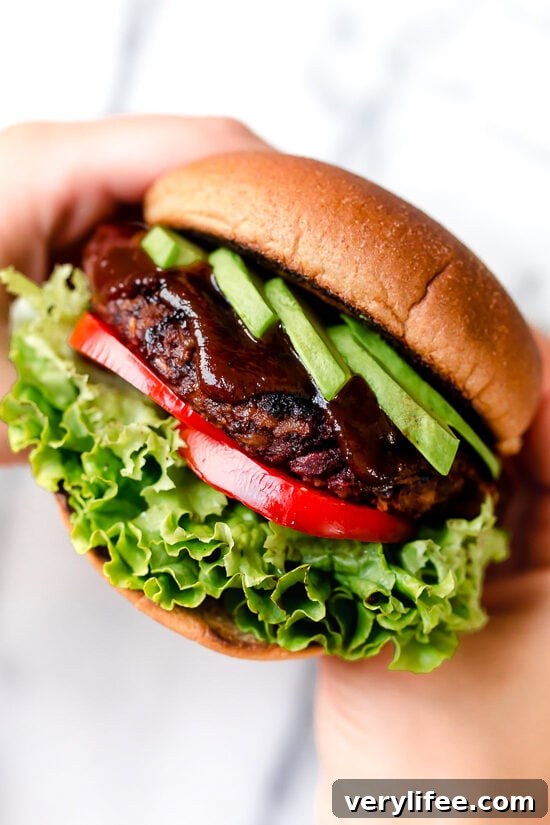 Hands holding veggie burger on bun.