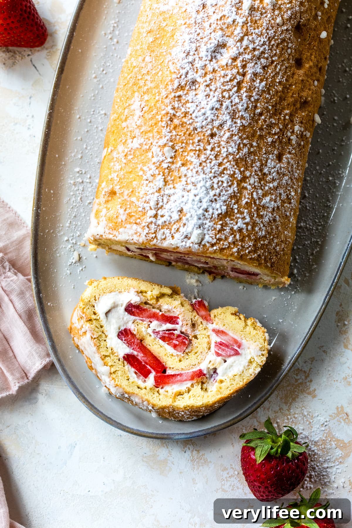 Strawberry Swiss Roll Recipe 5 Strawberry Swiss Roll with a slice taken out.