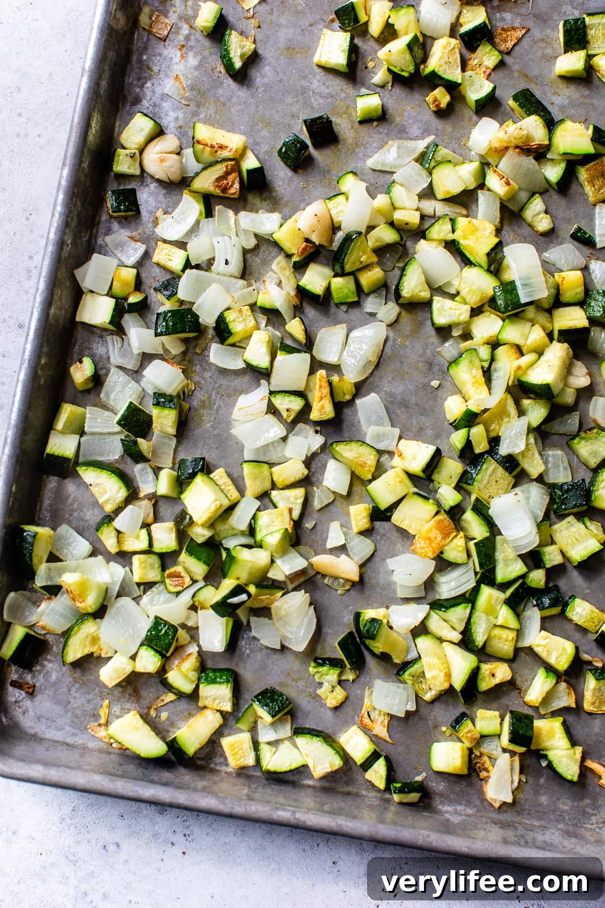 Roasted zucchini and aromatics on a sheet pan. Roasted zucchini, onions and garlic on a sheet pan.