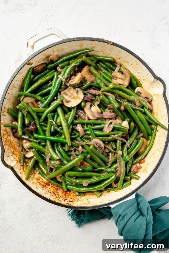 Garlic Sauteed Green Beans with Mushrooms 7 Cooked green beans with mushrooms in skillet