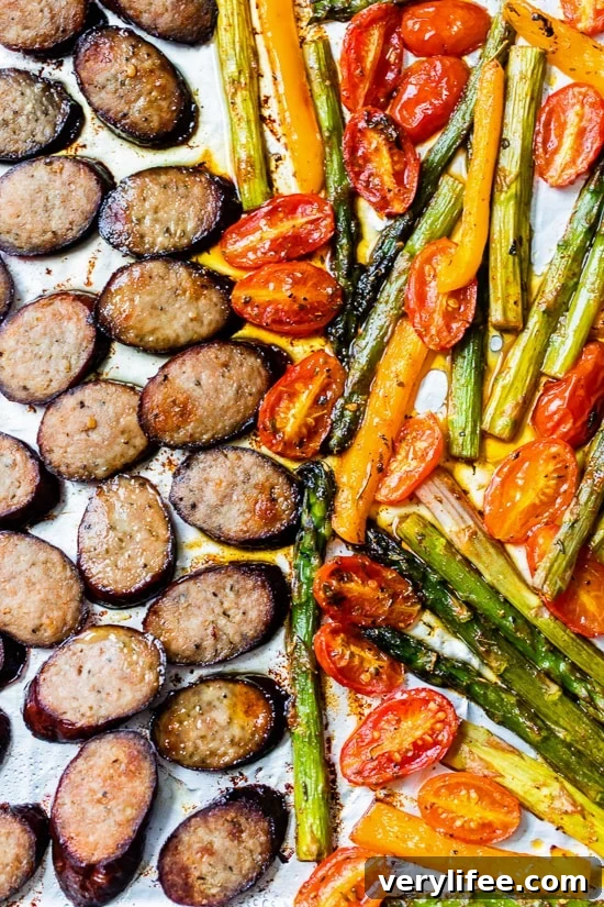 Kielbasa Veggie Sheet Pan Dinner with turkey kielbasa, asparagus, tomatoes and peppers.