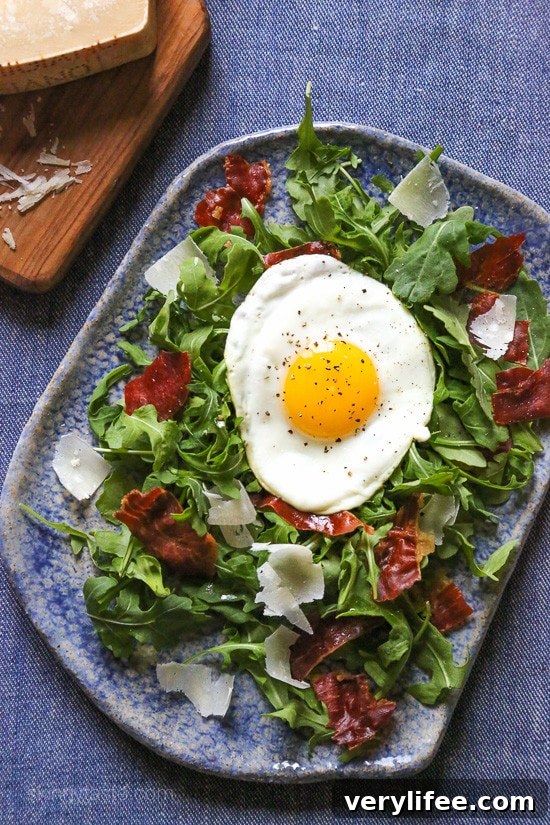 Arugula salad topped with crispy prosciutto, Parmesan, and a fried egg.