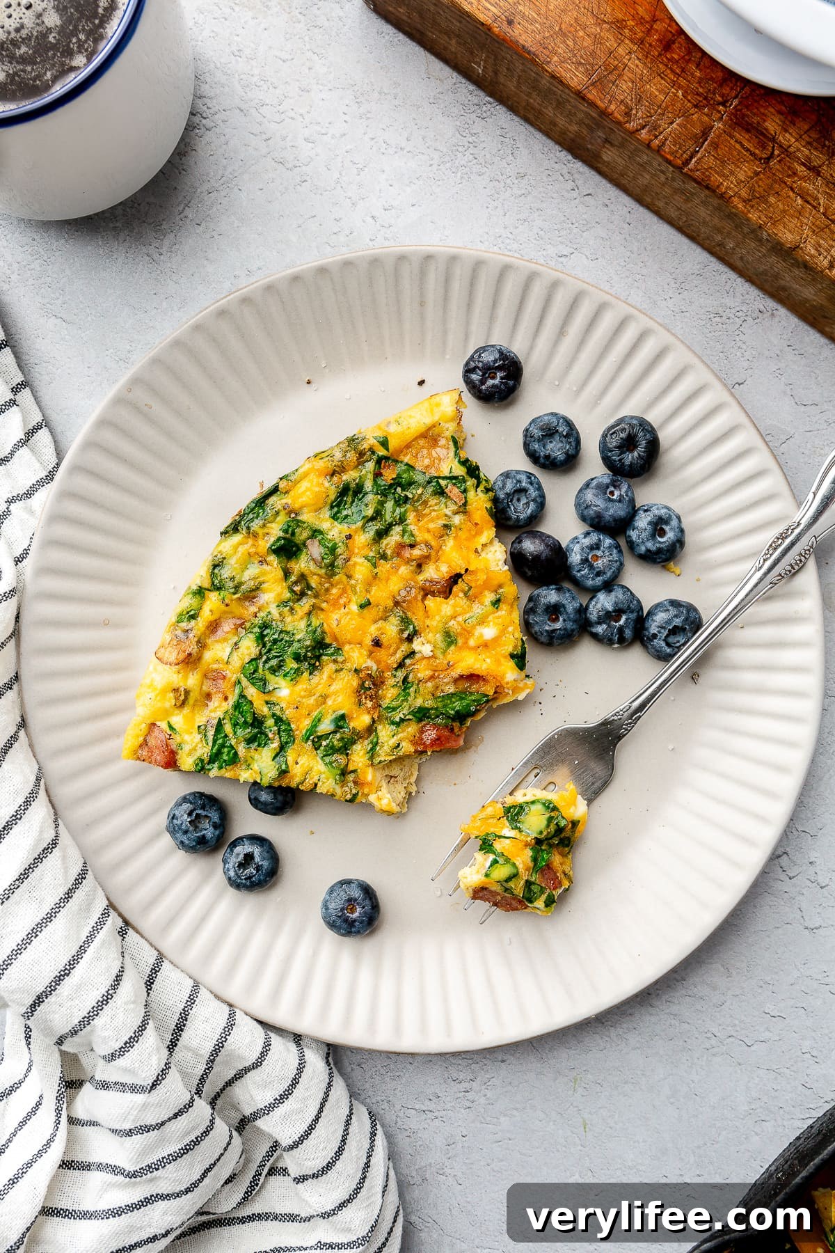 Smoked Turkey Sausage Breakfast Skillet with Eggs and Potatoes 10 Sausage breakfast frittata on a plate next to fresh blueberries.