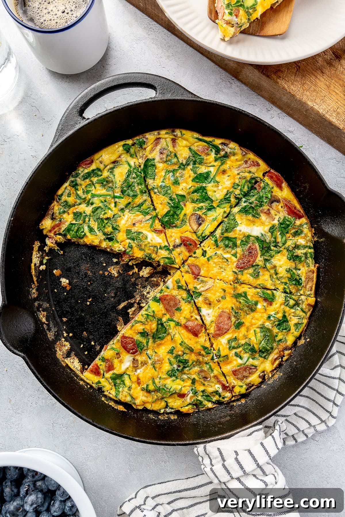 Smoked Turkey Sausage Breakfast Skillet with Eggs and Potatoes 9 Overhead view of a sausage breakfast frittata in a skillet with a slice missing.