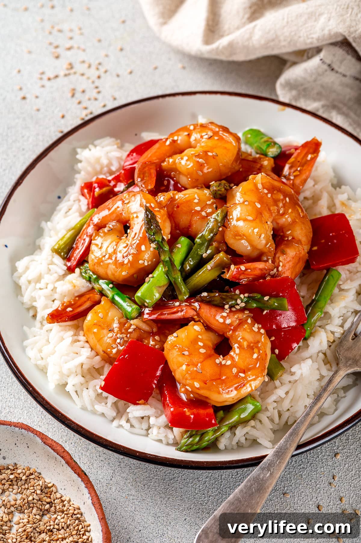 Shrimp and vegetables in a bowl over rice.
