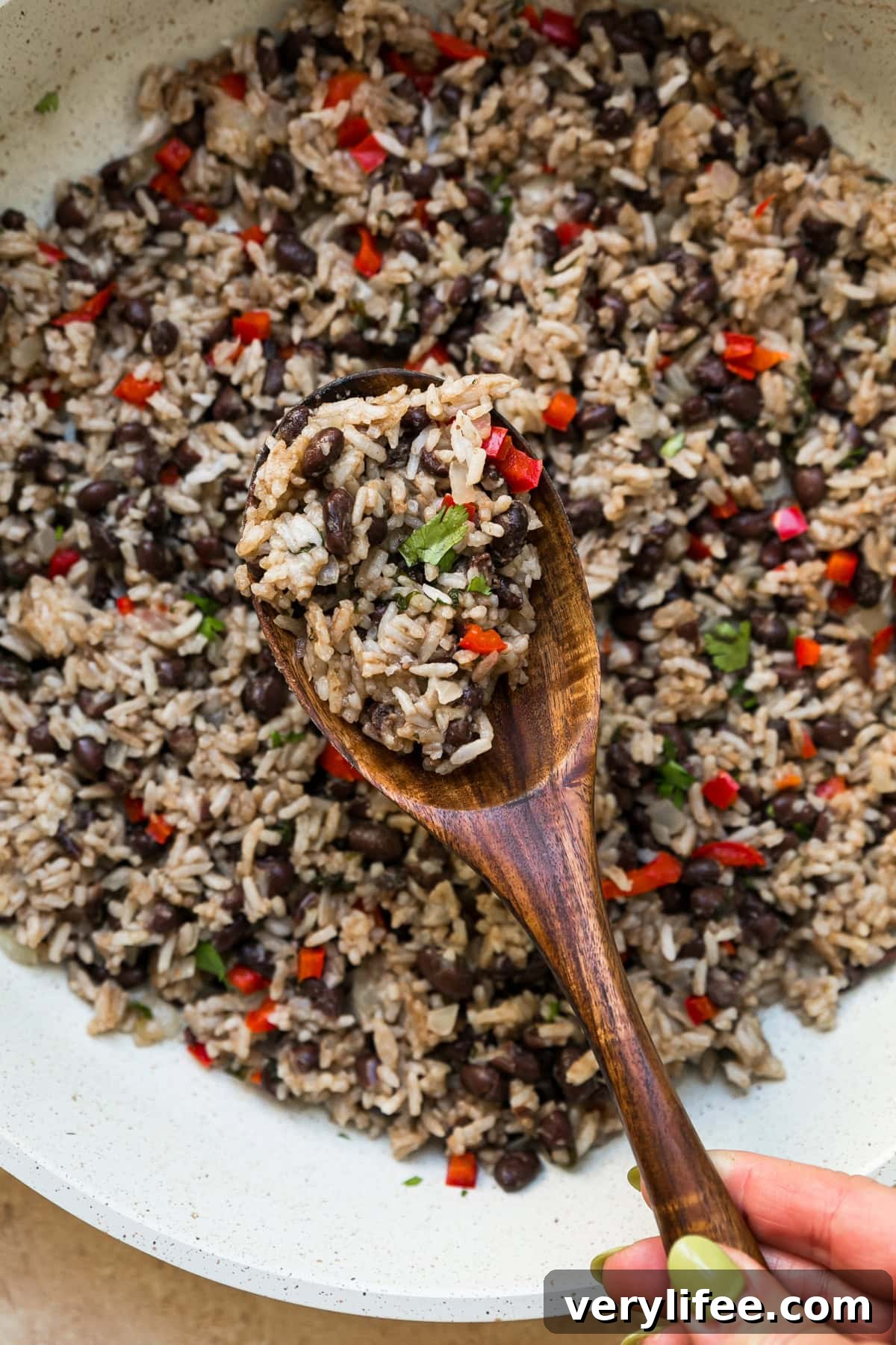 Gallo Pinto: Costa Rican Rice and Beans Recipe 5 Gallo Pinto in a skillet with wooden spoon