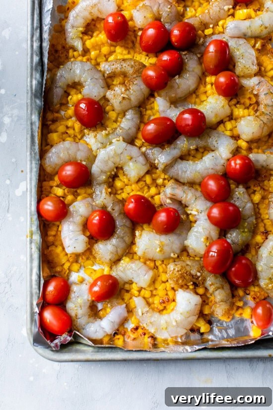 Baking sheet with corn, shrimp and tomatoes.