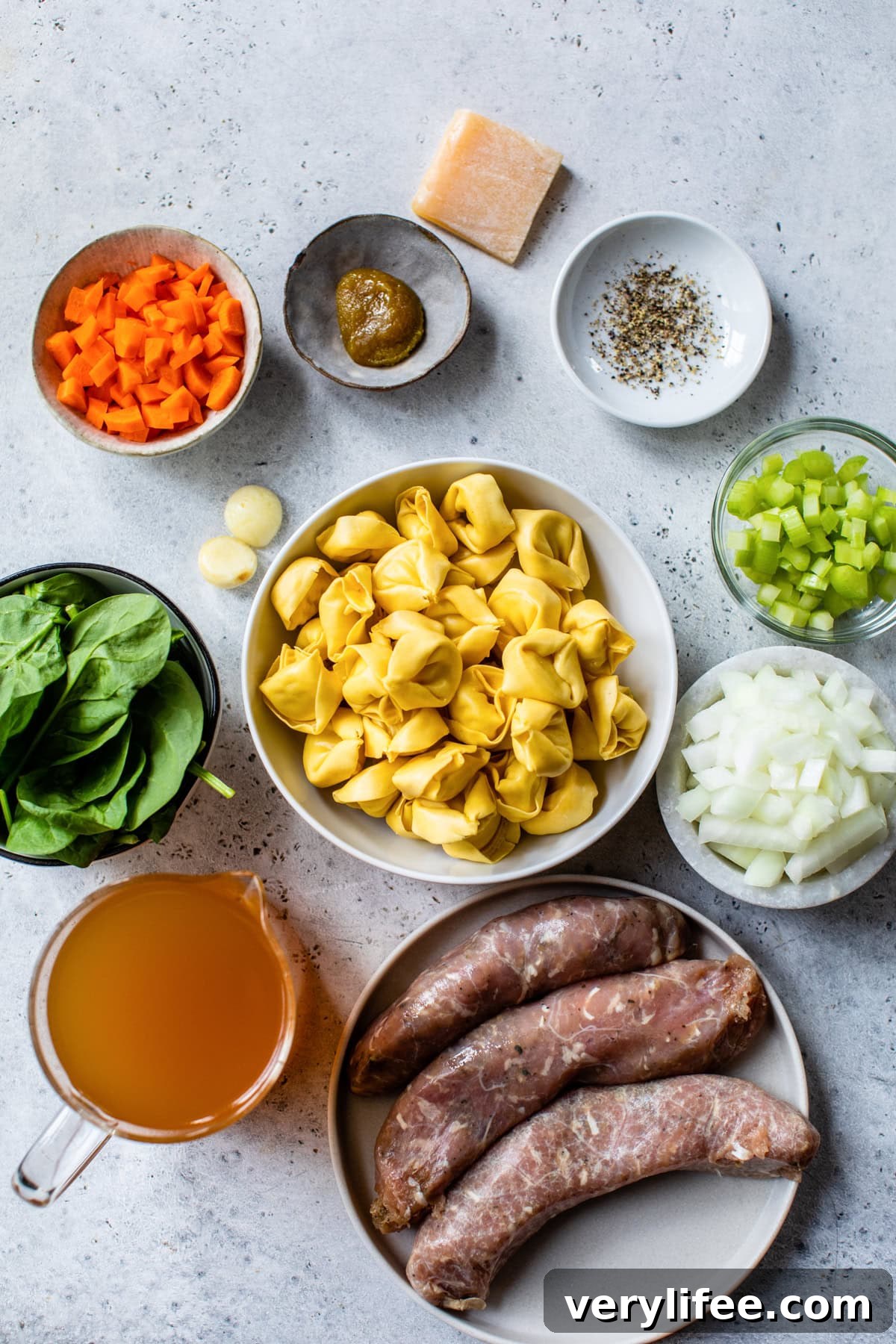Sausage, spinach, tortellini, broth, onions, celery and carrots for making soup