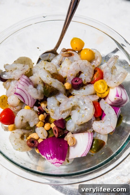Lemon Garlic Shrimp Foil Packets Recipe 5 Shrimp, tomatoes, olives, onion in a bowl