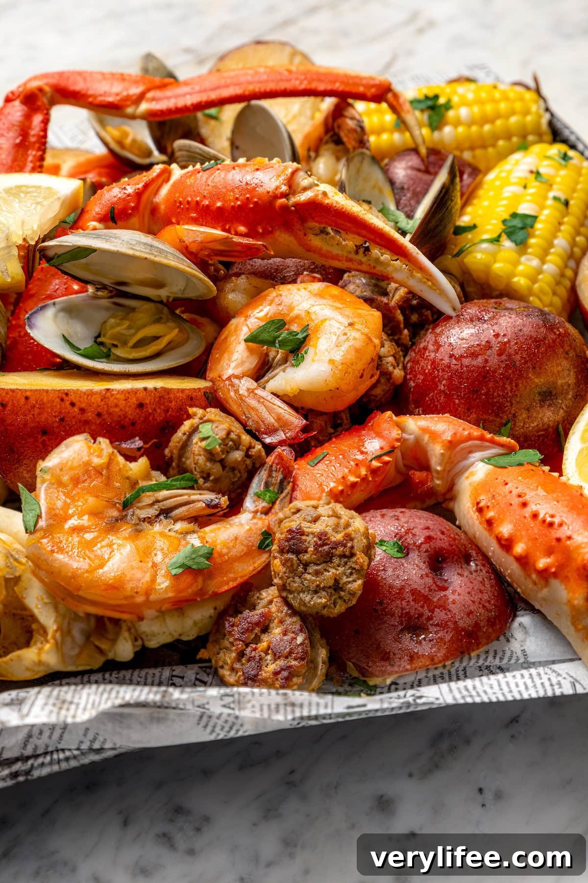 Closeup of seafood boil with crab legs, chorizo, shrimp, and clams