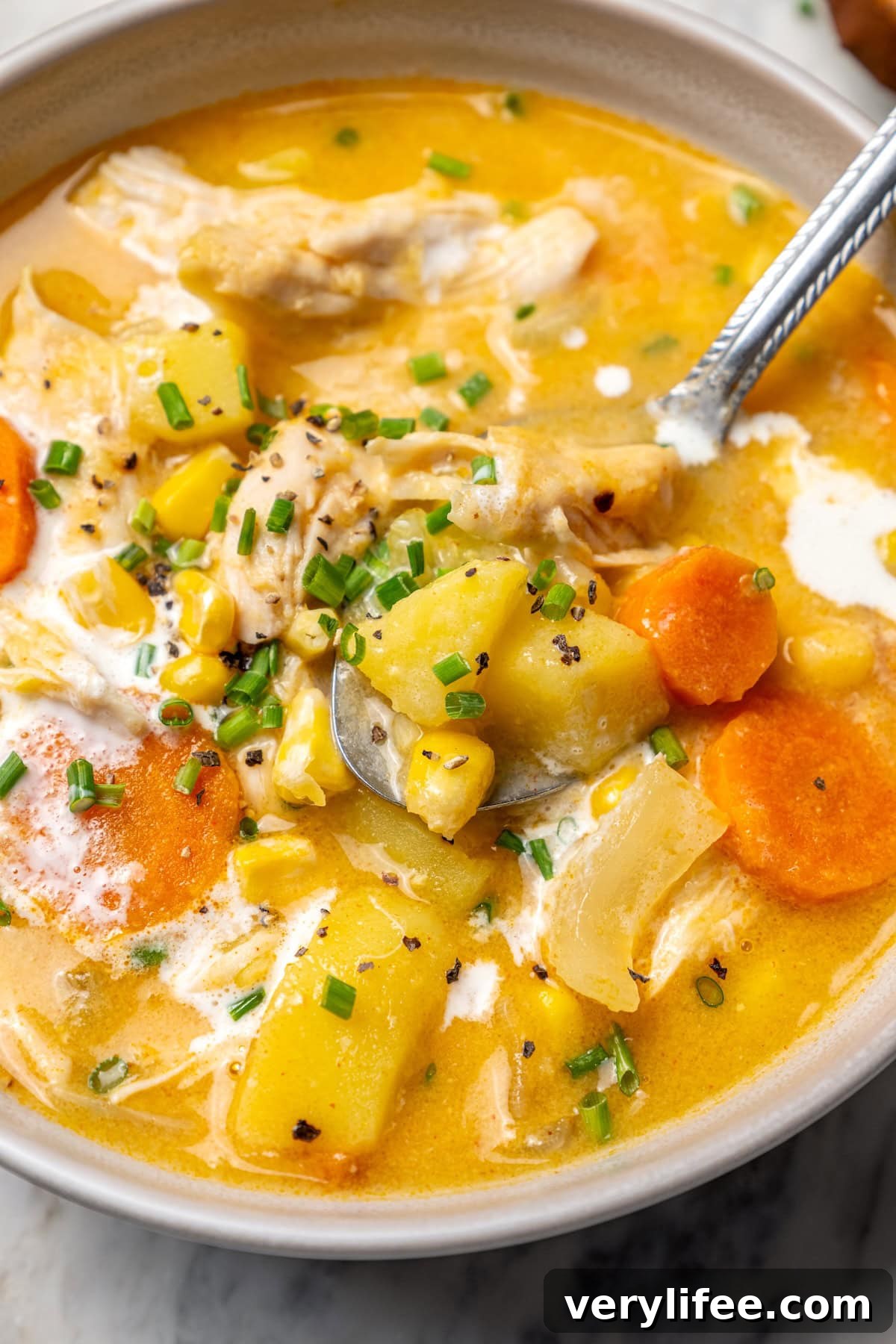 Creamy Chicken and Corn Chowder Recipe 10 Bowl of chicken corn chowder with spoon.