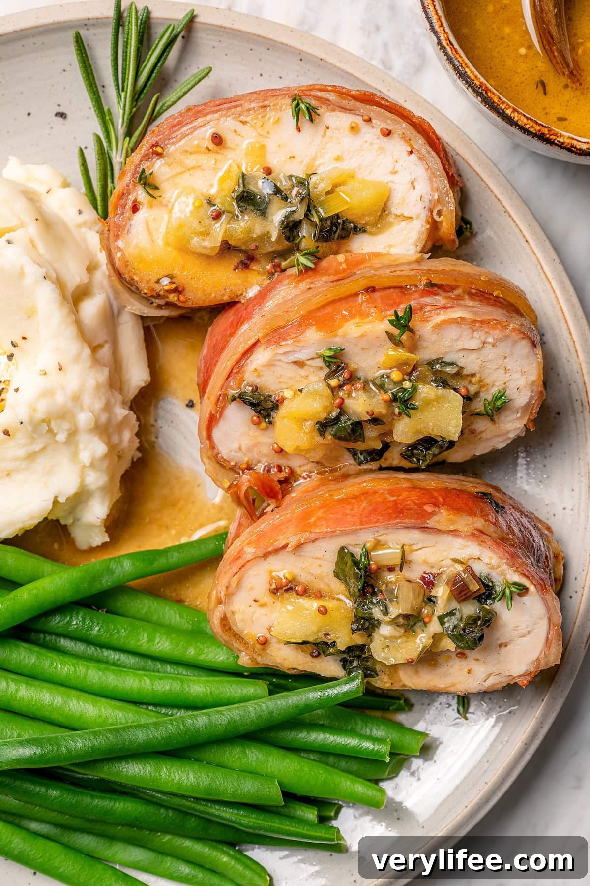 Prosciutto-Wrapped Turkey Tenderloin Stuffed with Apples, Kale 10 Plate with prosciutto-wrapped stuffed turkey tenderloin, green beans, and mashed potatoes.