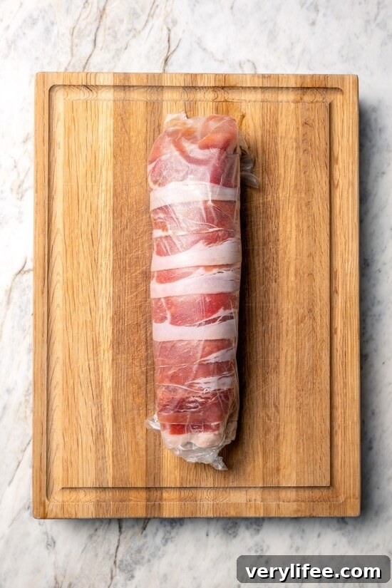 Prosciutto-Wrapped Turkey Tenderloin Stuffed with Apples, Kale 7 Turkey tenderloin wrapped in prosciutto and layer of plastic wrap.