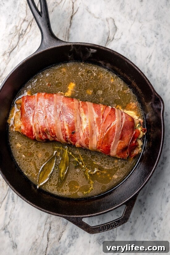 Prosciutto-Wrapped Turkey Tenderloin Stuffed with Apples, Kale 8 Skillet with prosciutto-wrapped stuffed turkey tenderloin and broth.