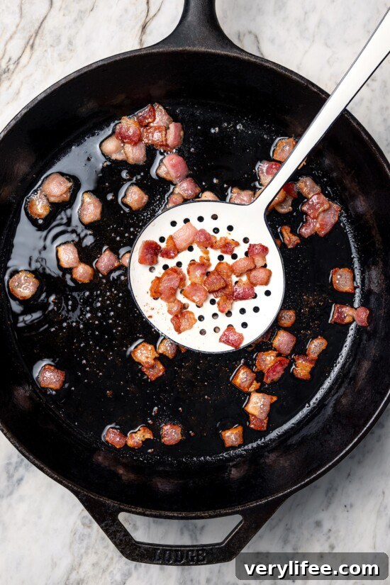 Bacon being removed from skillet.