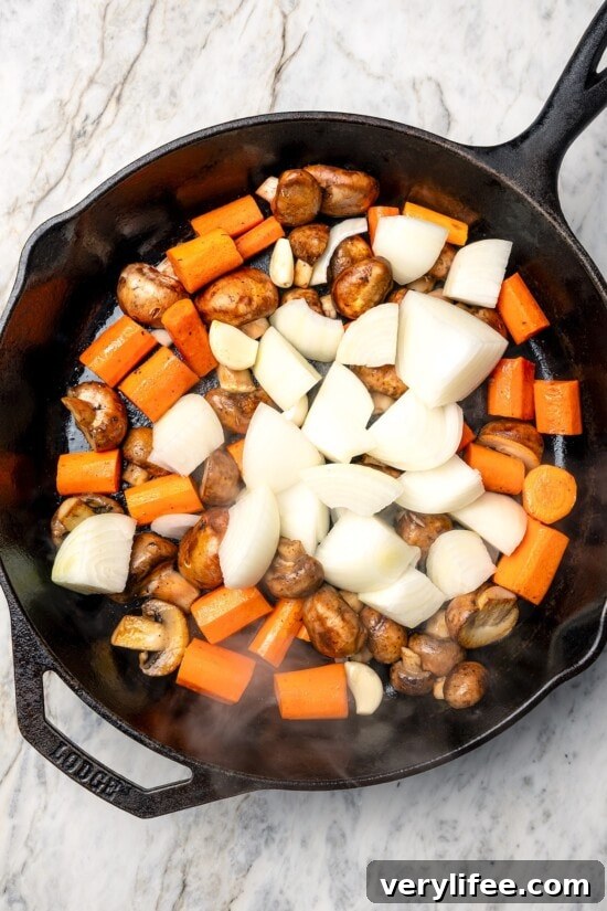 Vegetables in skillet for coq au vin.