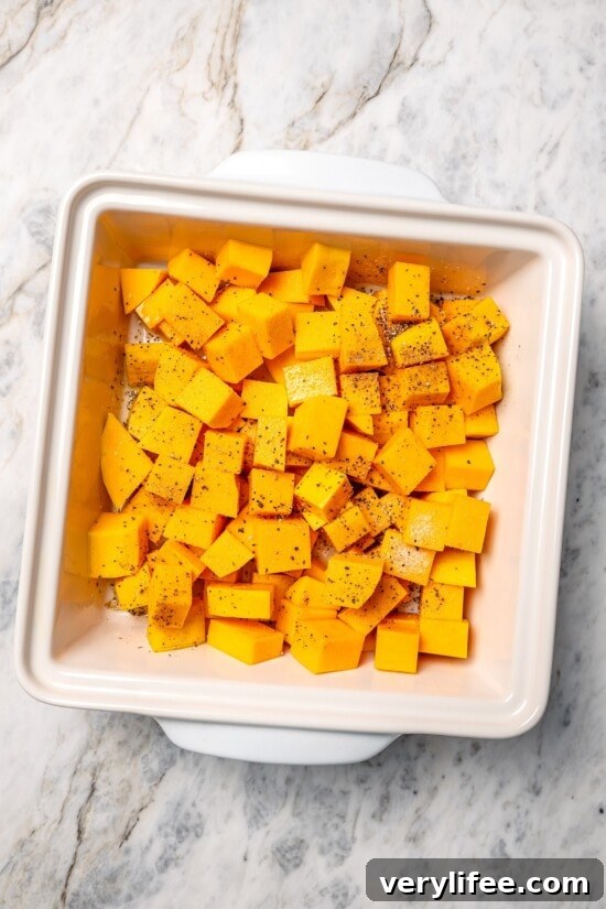 Seasoned butternut squash in baking dish.