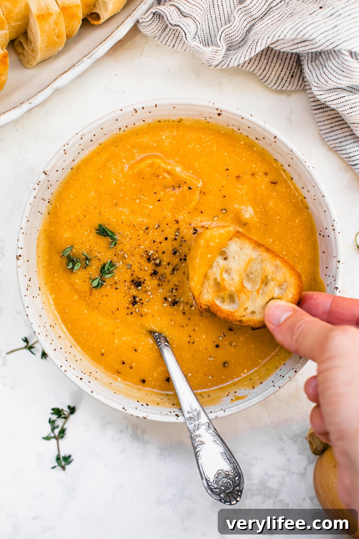 Butternut Squash Cheddar Soup in a bowl with bread