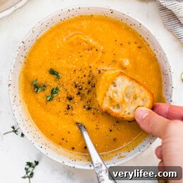 Butternut Squash Cheddar Soup in a bowl with bread