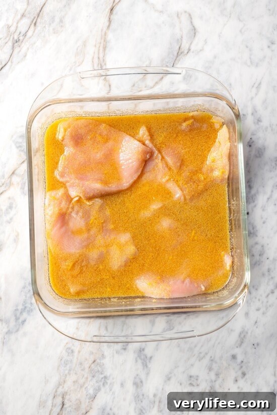 Chicken breasts in pan of marinade.