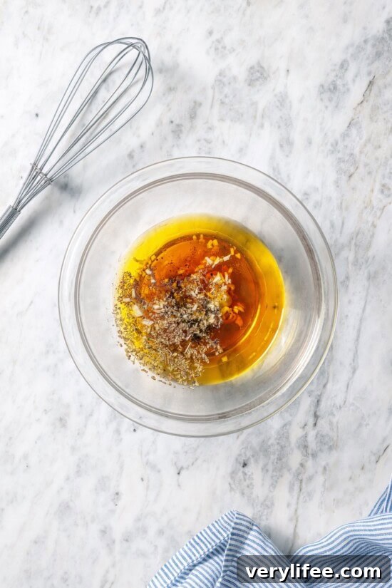 Classic Greek Salad Dressing Recipe with Olive Oil and Herbs 5 Ingredients for Greek salad dressing in bowl.