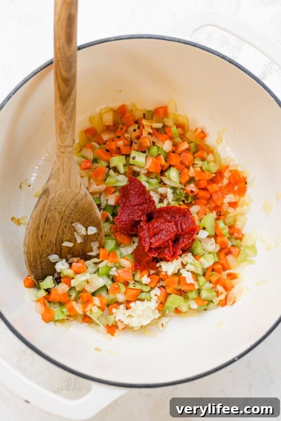 celery, carrots, onions and tomato paste in a pot