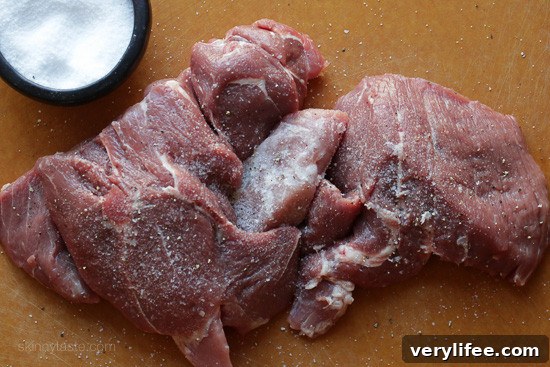 Instant Pot Carnitas: Authentic Mexican Pulled Pork 4 Raw pork shoulder cut into four pieces and seasoned with salt on a countertop.
