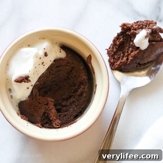 A ramekin of flourless chocolate cake next to a spoonful of cake