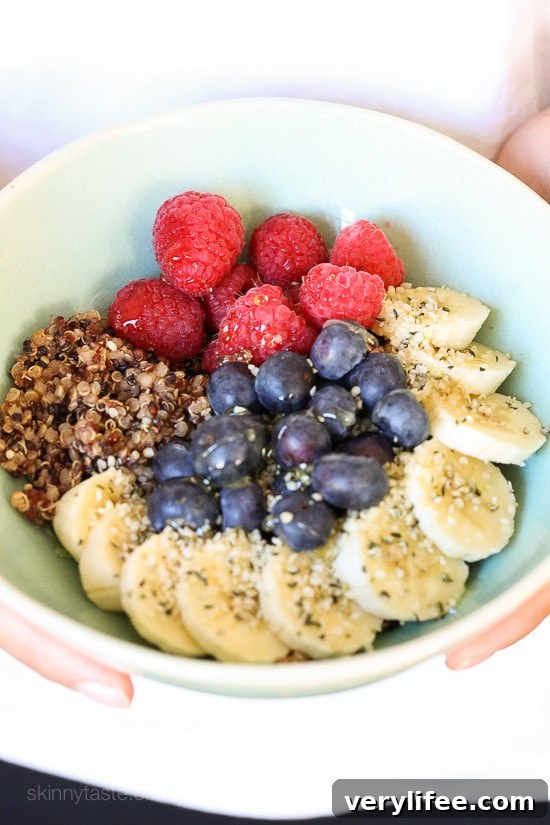 Creamy Berry Quinoa Breakfast Bowl Recipe 3 A bowl with quinoa, sliced bananas, fresh blueberries and raspberries sprinkled with hemp seeds