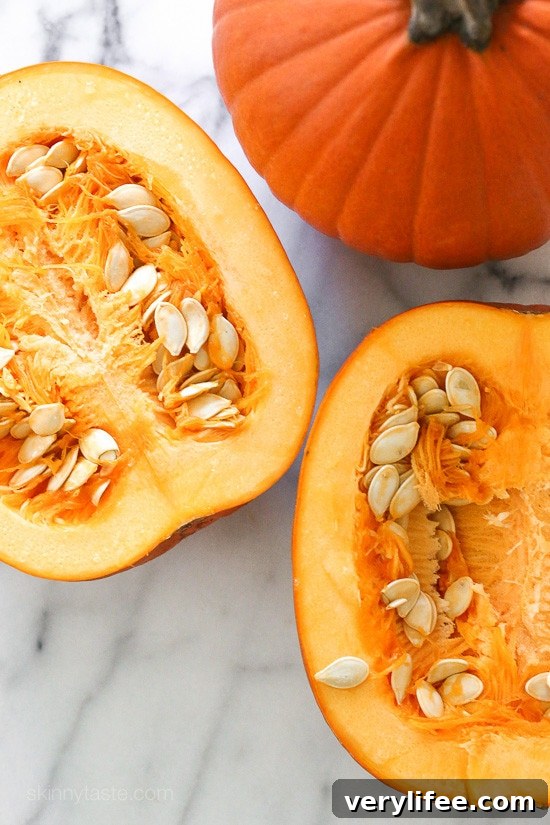 These Spicy Pumpkin Seeds are a fun twist on roasted pumpkin seeds. They make a tasty, filling snack on their own and a great salad topper. A small pumpkin cut in half to show the seeds