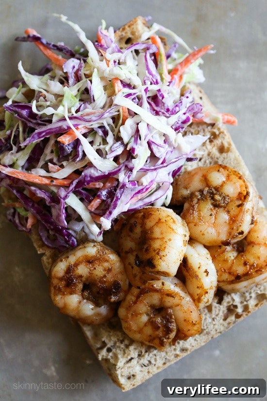 Overhead view of a shrimp po' boy assembled on French bread.