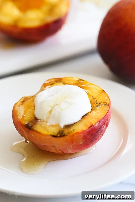 Two grilled peach halves topped with yogurt and drizzled with honey