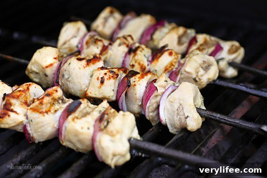 Served chicken skewers with lemon wedges