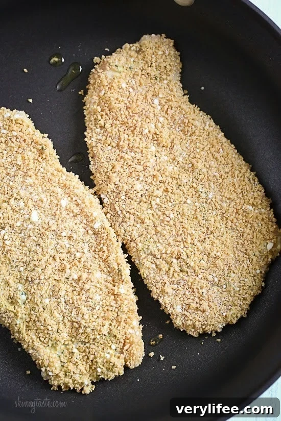 Mustard Herb Crusted Chicken Breasts cooking on a pan.
