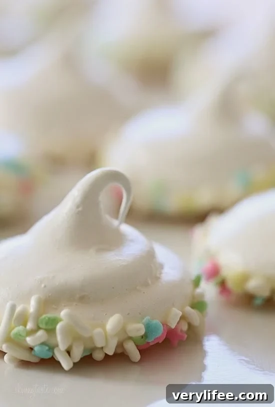 Sprinkle Dipped Meringues – Melt-in-your-mouth meringues dipped in white chocolate and sprinkles!