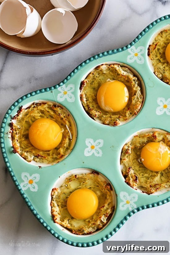 Spaghetti Squash Nests with Baked Eggs Recipe 3 A muffin pan lined with spaghetti squash mixture and a raw egg on top of each