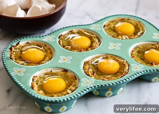 Spaghetti Squash Nests with Baked Eggs Recipe 7 A muffin tin with spaghetti squash mixture and topped with a raw egg in each tin