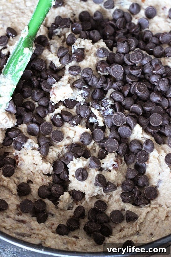 Slice of deep dish chocolate chip cookie pie topped with frozen yogurt.