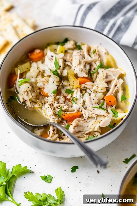 Classic Chicken and Barley Soup Recipe 4 Chicken Barley Soup in a bowl with spoon.