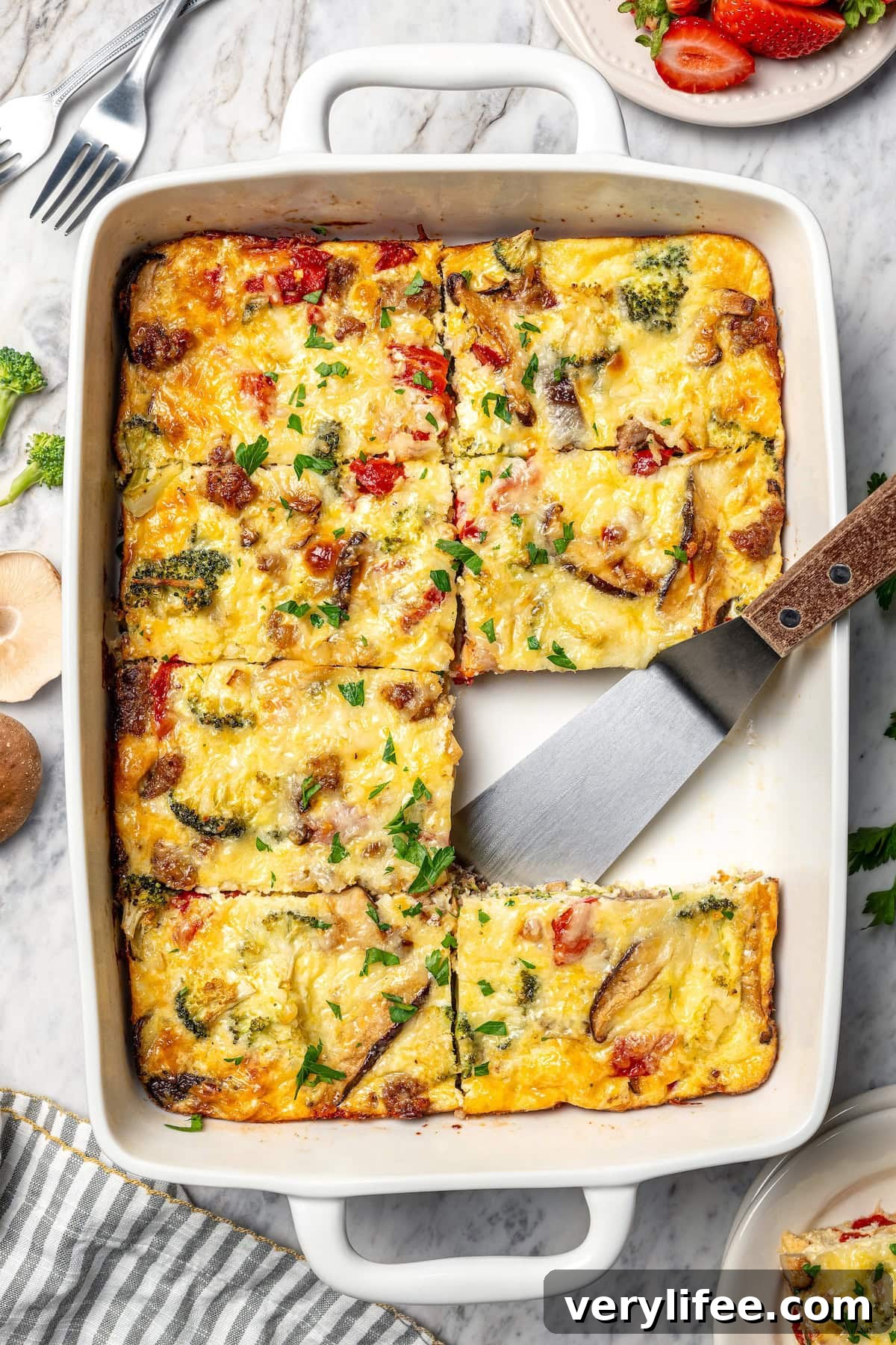 Breakfast casserole in baking dish with one portion removed.
