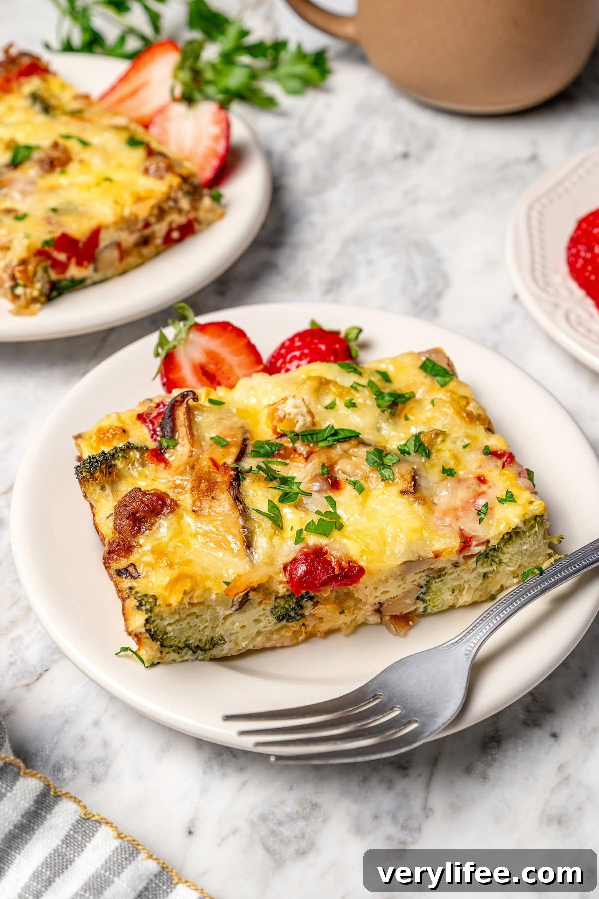Slice of breakfast casserole on plate with fork.