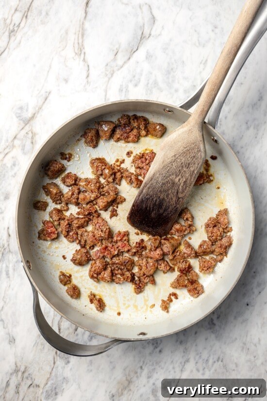 Sausage browning in skillet.