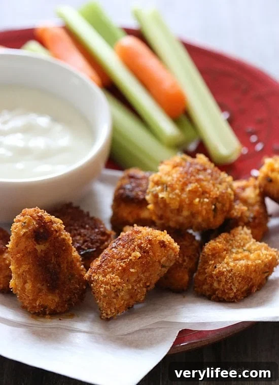 Baked Buffalo Chicken Nuggets A plate of crispy baked buffalo chicken nuggets with carrots and celery sticks and creamy dipping sauce