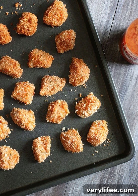 Crispy Oven-Baked Buffalo Chicken Nuggets 4 A baking sheet with uncooked breaded chunks of chicken.