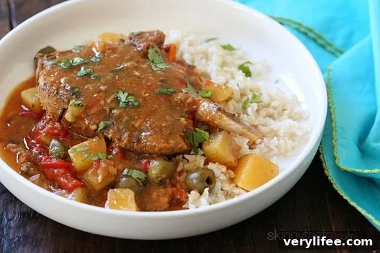 These slow cooker pork chops are seasoned with Latin spices in a flavorful sauce with tomatoes, olives, peppers and potatoes. They literally fall off the bone when they come out of the slow cooker!