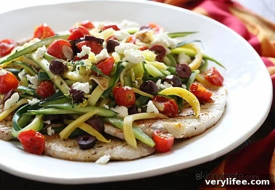 Pan seared thin pork chops topped with julienned summer squash, roasted tomatoes, lemon, olives and Feta