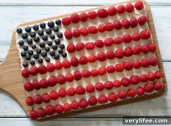 Red, White and Blue fruit "pizza" is more like a cookie bar, topped with cream cheese frosting and fruit – The perfect 4th of July dessert!