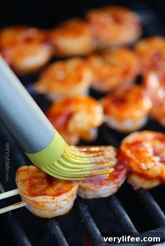 brushing bbq sauce on shrimp skewers