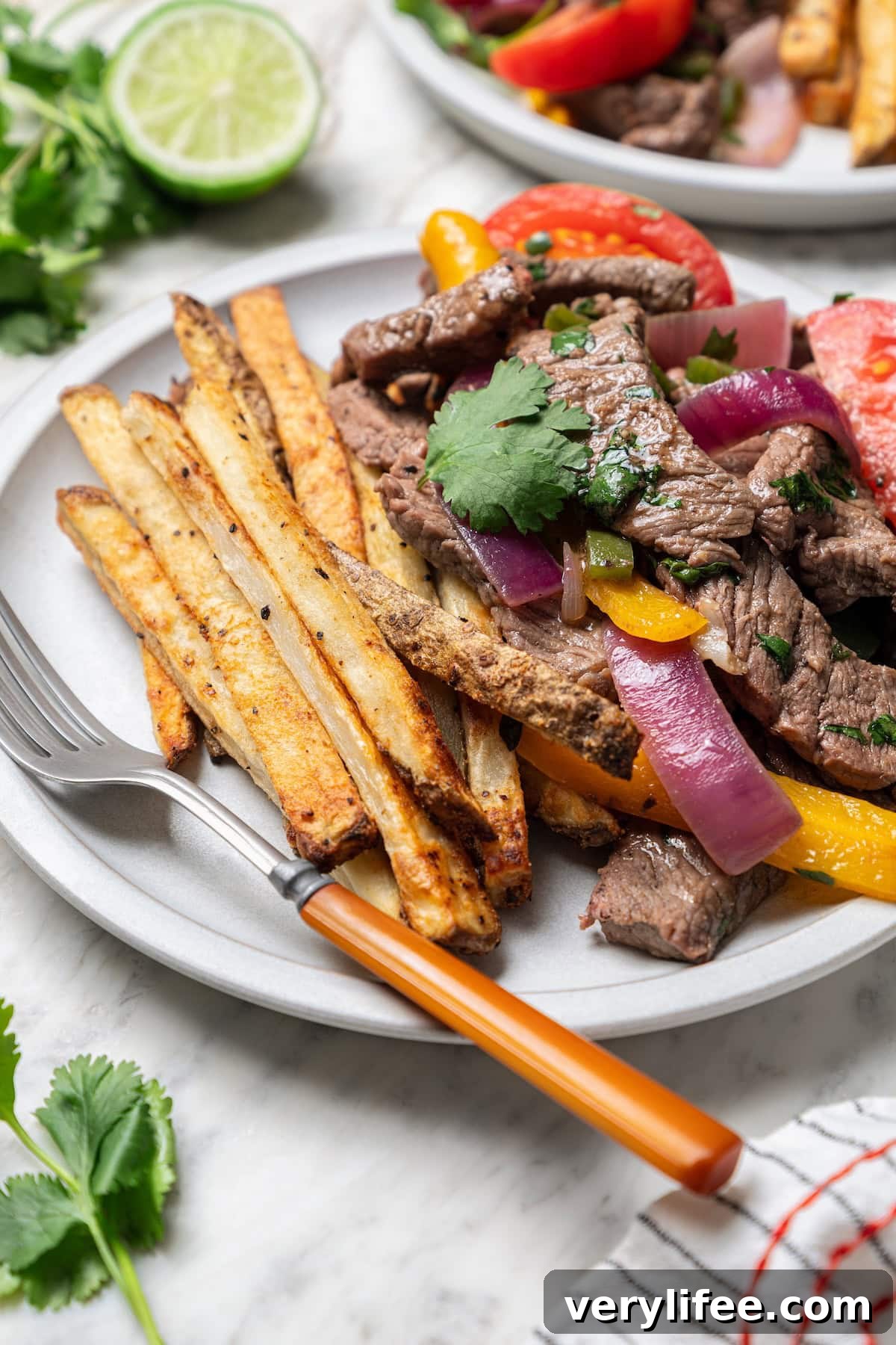 Peruvian Lomo Saltado: Authentic Stir-Fried Beef and Fries 11 Lomo saltado beef stir fry on plate with fork