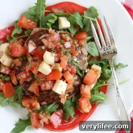Naked Turkey Bruschetta Burger are healthy, delicious, turkey burgers made juicy thanks to added zucchini and topped with a summer garden tomato bruschetta topping over a bed of baby arugula – no bun required!